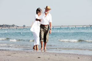 Senior couple stolling on the beach. Cross-processed image.
